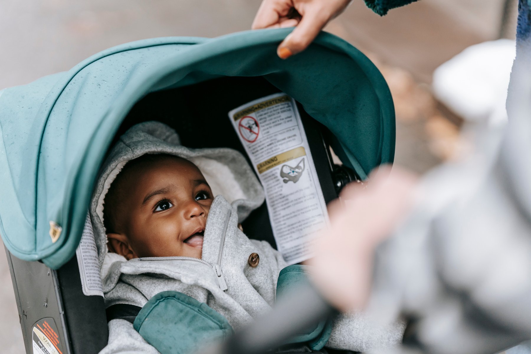 Smiling cute ethnic baby in stroller with parents